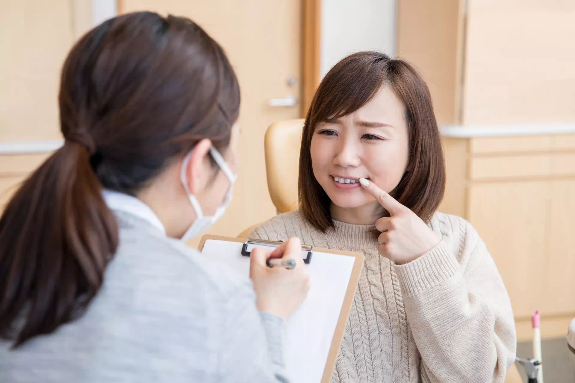 歯肉再生について相談する女性の画像
