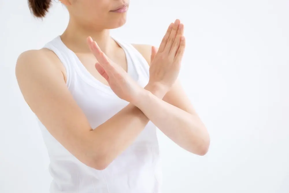 バツマークをする女性の画像